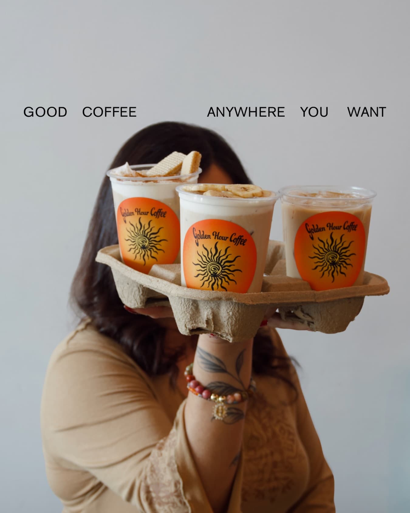 A hand holding out a pulp tray of Golden Hour cups toward the camera, each with the orange sun sticker.